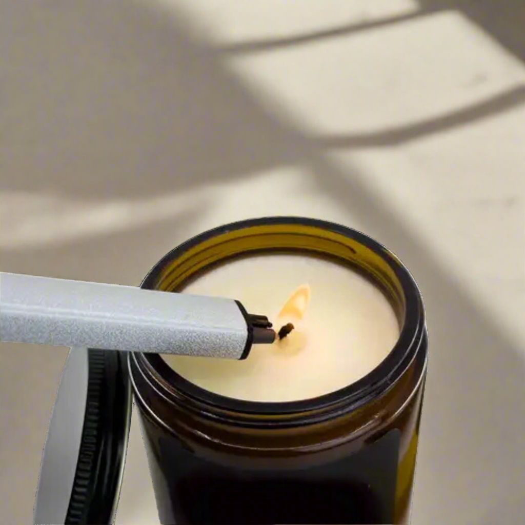 Electric flameless candle torch in use, rechargeable alternative to traditional butane lighter